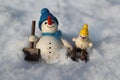 Wooden snowman and small snowman sledding in the snow Royalty Free Stock Photo