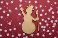 A wooden snowman waving his hand against a red background, a Christmas and New Year`s card Royalty Free Stock Photo