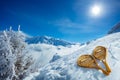 Wooden snowshoes over snow high in mountains with sun and mist