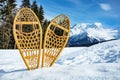 Pair of the wooden snowshoes in snow over mountain peaks