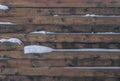 Wooden solid fence made of boards with snow. Abstract background, selective focus