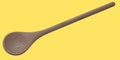 Wooden solid spoon or kitchen utensils on yellow background.