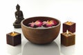 Wooden Spa Bowl on White Background with Buddha Statue,Candles and Flowers Royalty Free Stock Photo