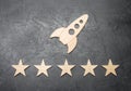 A wooden space rocket and five stars on a concrete background. The concept of space travel, commercial launches into space. Royalty Free Stock Photo