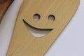 A wooden spatula with a cut-out smile isolated on a white background kitchen utensils Royalty Free Stock Photo