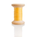 Wooden spool with yellow threads, embroidery and sewing, tailor isolated on a white background