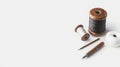 Wooden spools of black and white thread with calligraphy pens and tools on a white background, creating a minimalist and elegant Royalty Free Stock Photo