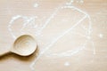 Wooden spoon with abstract flour on cutting board