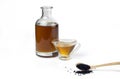 Wooden spoon with black cumin seeds and black seed oil in a glass bottle and gravy boat. Royalty Free Stock Photo