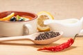 Wooden spoon with black peppercorn, dried red pepper on cutting Royalty Free Stock Photo
