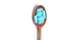 Wooden spoon with blue pills white background. Concept medicine and health Royalty Free Stock Photo