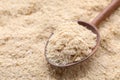 Wooden spoon of brewer`s yeast on flakes, closeup. Space for text