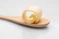 Wooden spoon with butter curl Royalty Free Stock Photo