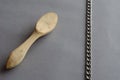 Wooden spoon carving buckshot and chain against a gray background