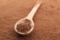 Wooden spoon and cocoa powder background, close up Royalty Free Stock Photo