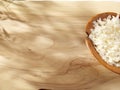 A wooden spoon with coconut chips on a sunny wooden background