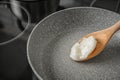 Wooden spoon with coconut oil in frying pan Royalty Free Stock Photo