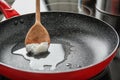 Wooden spoon with coconut oil in frying pan. Royalty Free Stock Photo