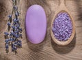 Wooden spoon with crystal sea salt bunch of lavender bar soap on wood board spa treatment concept Royalty Free Stock Photo