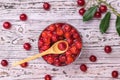 Wooden spoon in a Cup of cherry jam on a wooden table. Homemade jam from the fresh harvest of cherry berries. Flat lay. Royalty Free Stock Photo