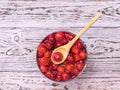 Wooden spoon in a Cup of freshly made cherry jam on a wooden background. Flat lay. Royalty Free Stock Photo