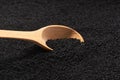 wooden spoon filled with black caraway seeds. food background