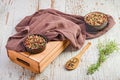 Wooden spoon filled with fresh peppercorns atop a tray on a white table