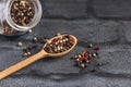 Wooden spoon full of aromatic colorful pepper