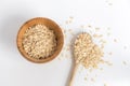 Wooden spoon full of oat flakes taken from a wooden bowl on a white background. Royalty Free Stock Photo