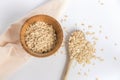 Wooden spoon full of oat flakes taken from a wooden bowl on a white background. Royalty Free Stock Photo