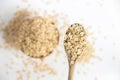 Wooden spoon full of oat flakes taken from a wooden bowl on a white background. Royalty Free Stock Photo