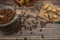 Wooden spoon in a glass jar with coffee beans, coffee grinder, pieces of brown sugar on a wooden background. Close up Royalty Free Stock Photo