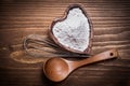 Wooden spoon heartshaped bowl flower egg-whisk on wood board Royalty Free Stock Photo