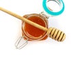 Wooden spoon for honey lies on an open glass jar with floral golden honey on a white background Royalty Free Stock Photo