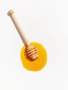 Wooden spoon for honey and spilled honey on a white background. Top view