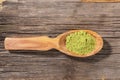 Wooden spoon with japanese green matcha tea powder on old wooden board. Top view Royalty Free Stock Photo