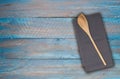 Wooden spoon and kitchen towel on blue-gray wooden background Royalty Free Stock Photo