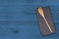 Wooden spoon and kitchen towel on blue wooden background Royalty Free Stock Photo