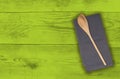 Wooden spoon and kitchen towel on green wood Royalty Free Stock Photo