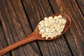 Wooden spoon with oat-flakes on a wooden board