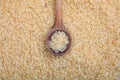 Wooden spoon and parboiled rice background Royalty Free Stock Photo
