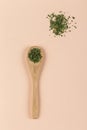 Wooden spoon with Parsley on pink background