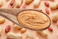 Wooden spoon with peanut butter. Peanuts lay on beige at the background. Top view Royalty Free Stock Photo