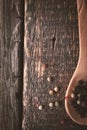 Wooden spoon with pepper mix on the wooden background vertical Royalty Free Stock Photo