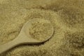 Wooden spoon on pile brown cane sugar texture background.