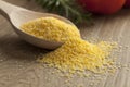 Wooden spoon with raw polenta Royalty Free Stock Photo