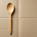 A wooden spoon rests on a textured cardboard surface. The spoon is smooth, light Royalty Free Stock Photo