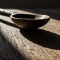 A wooden spoon rests on a textured wooden surface, casting a shadow. The spoon Royalty Free Stock Photo