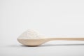 Wooden spoon with a slide of flour on a white background. macro side view. ingredients for making desserts, pastries, bread, cake,