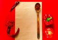 Wooden spoon with spices and ingredients for cooking paste on old newspaper texture on red background.Frame of organic food. Royalty Free Stock Photo